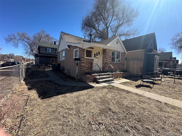 view of front of property featuring stone siding and fence