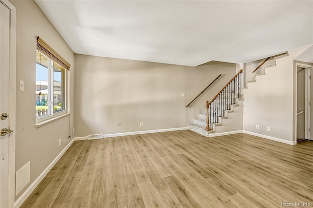 6885 E Arizona Ave Unit D, Denver, CO 80224 - unfurnished living room with light wood-type flooring, stairs, and baseboards