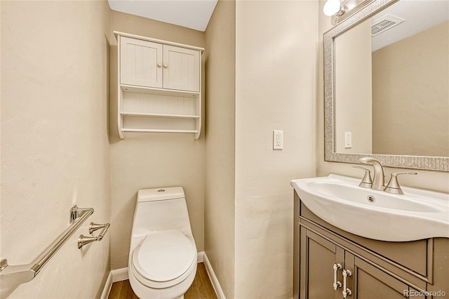 bathroom featuring toilet, vanity, and hardwood / wood-style floors