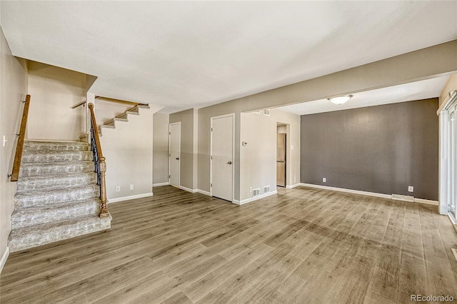 6885 E Arizona Ave Unit D, Denver, CO 80224 - unfurnished living room featuring wood finished floors, stairs, and baseboards