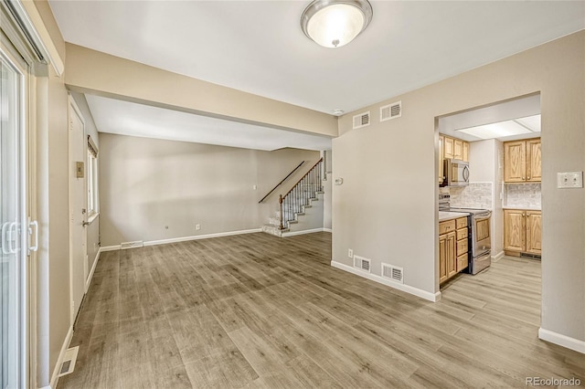 6885 E Arizona Ave Unit D, Denver, CO 80224 - empty room with stairs, light wood finished floors, and baseboards