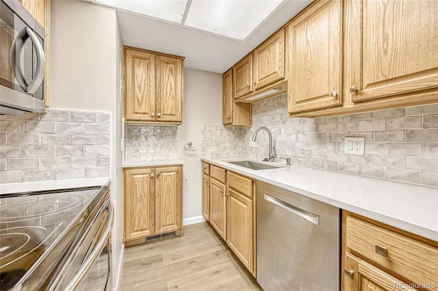 6885 E Arizona Ave Unit D, Denver, CO 80224 - kitchen featuring stainless steel appliances, a sink, tasteful backsplash, and light wood-type flooring
