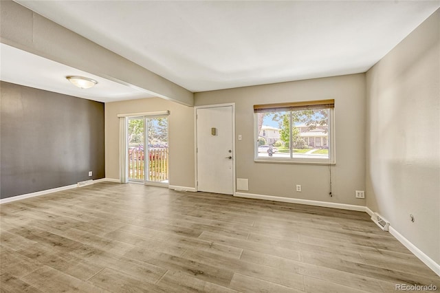 unfurnished room with a wealth of natural light and light wood-type flooring