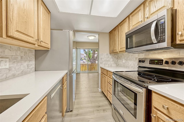 kitchen featuring light wood-type flooring, light brown cabinets, backsplash, and stainless steel appliances