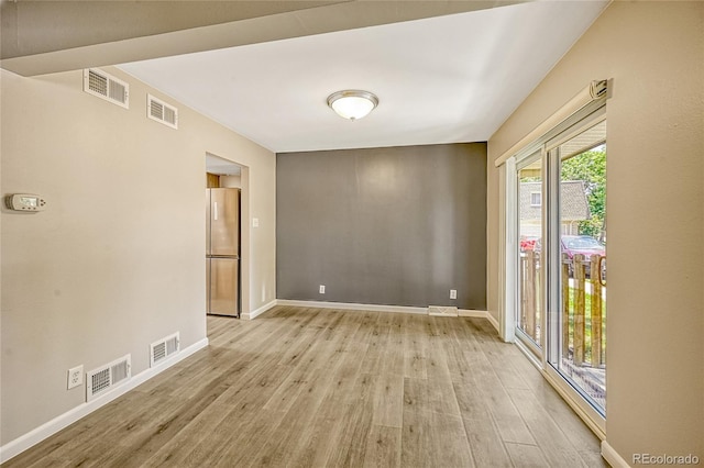 unfurnished room with light wood-type flooring