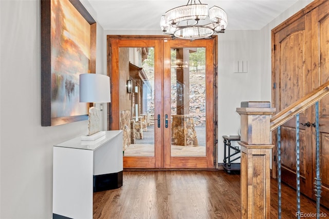 entryway with french doors, an inviting chandelier, and wood finished floors