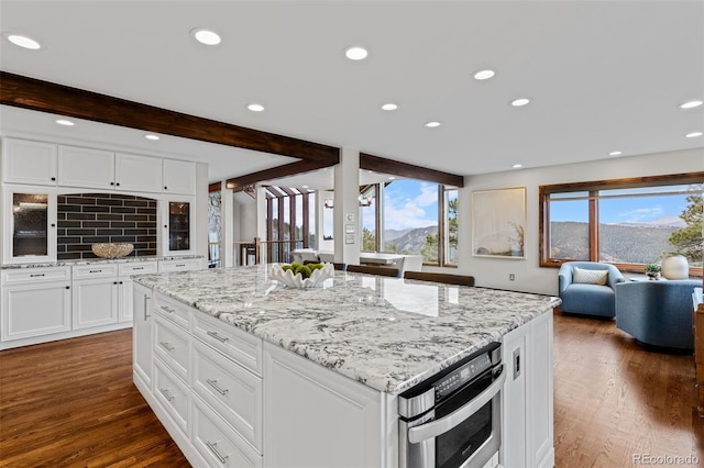 kitchen with white cabinetry, dark wood-type flooring, and light stone counters