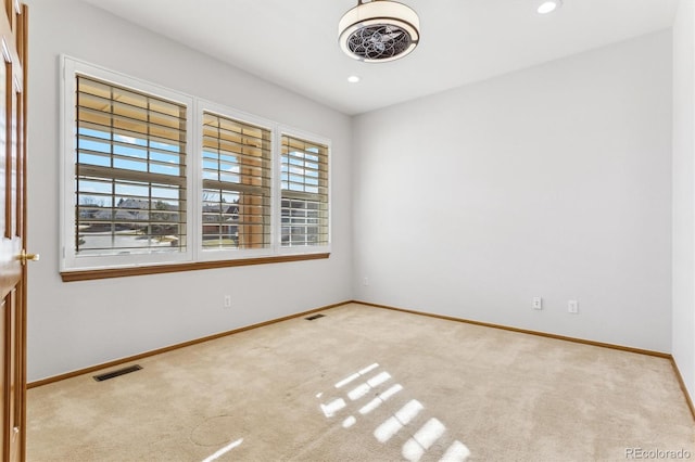 unfurnished room featuring light carpet