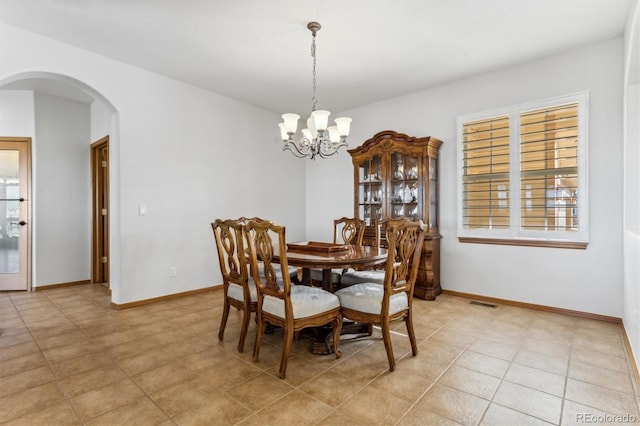 tiled dining room with a notable chandelier