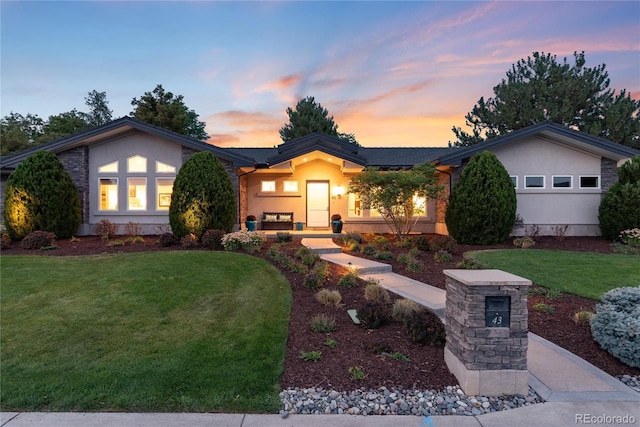 view of front of home with a garage and a lawn