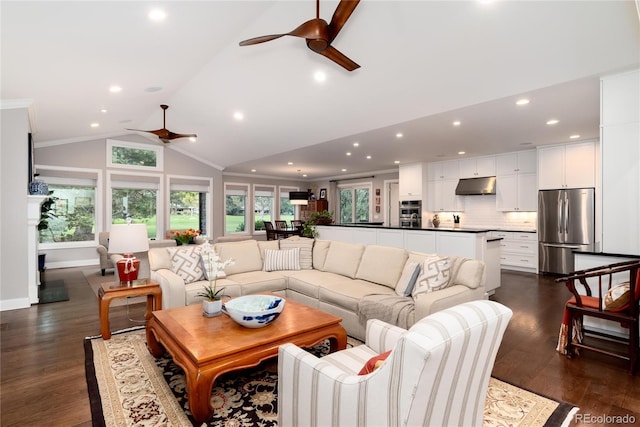 living room with lofted ceiling, dark hardwood / wood-style flooring, ornamental molding, and ceiling fan