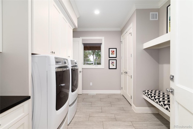 laundry room featuring crown molding, cabinets, and washer and clothes dryer