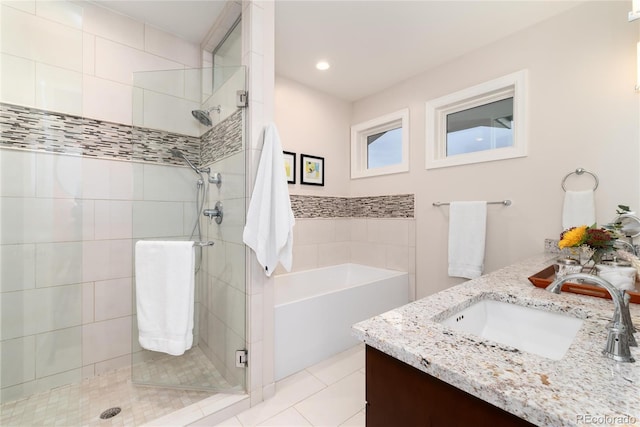 bathroom with tile patterned flooring, vanity, and plus walk in shower