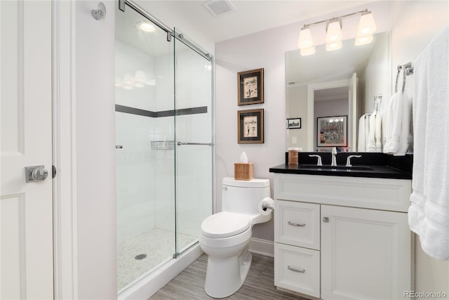 bathroom with vanity, wood-type flooring, toilet, and walk in shower