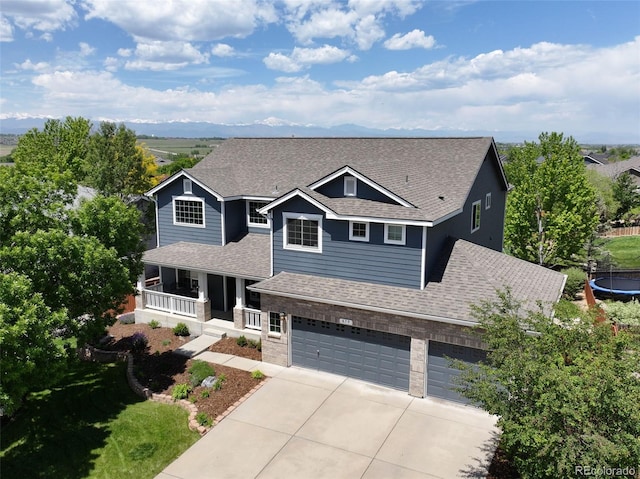 879 Quintana Ln, Erie, CO 80516 - view of front of property with a porch, a shingled roof, concrete driveway, a garage, and a trampoline