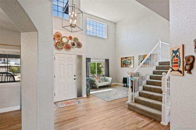 879 Quintana Ln, Erie, CO 80516 - entryway with a high ceiling, wood finished floors, stairway, a chandelier, and baseboards