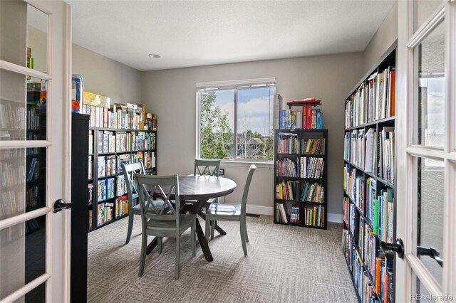 879 Quintana Ln, Erie, CO 80516 - carpeted home office featuring french doors, wall of books, and baseboards