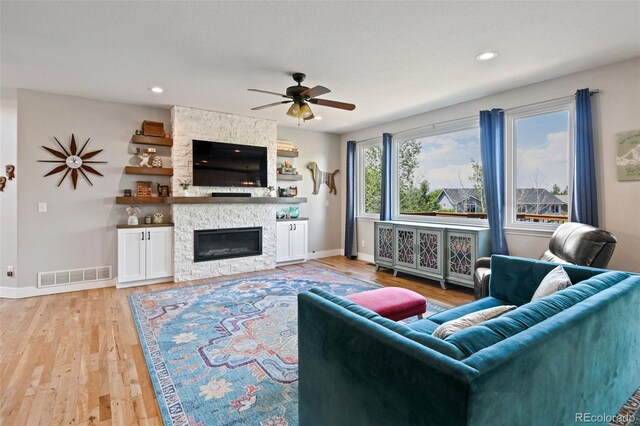 879 Quintana Ln, Erie, CO 80516 - living area featuring a ceiling fan, baseboards, a stone fireplace, light wood-type flooring, and recessed lighting
