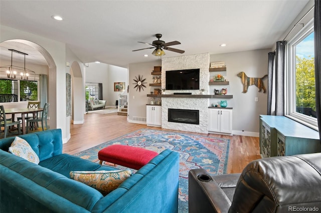 879 Quintana Ln, Erie, CO 80516 - living room featuring arched walkways, a ceiling fan, light wood-style floors, plenty of natural light, and recessed lighting