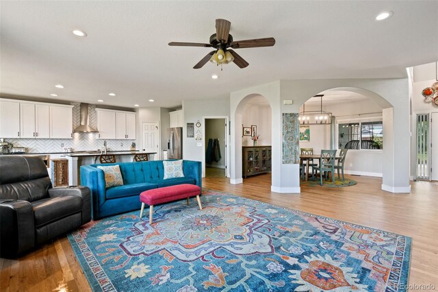 879 Quintana Ln, Erie, CO 80516 - living area with arched walkways, ceiling fan, light wood-style floors, baseboards, and recessed lighting