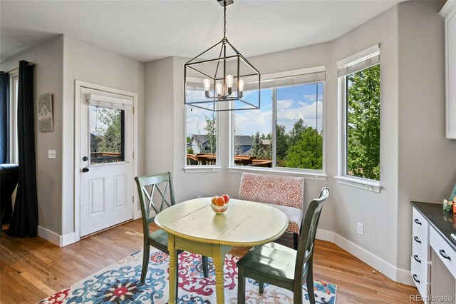 879 Quintana Ln, Erie, CO 80516 - dining room featuring baseboards, light wood finished floors, and a chandelier