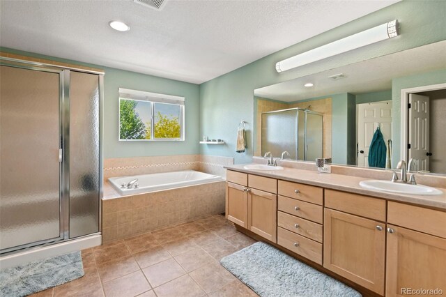 879 Quintana Ln, Erie, CO 80516 - bathroom with double vanity, a shower stall, tile patterned floors, a bath, and recessed lighting