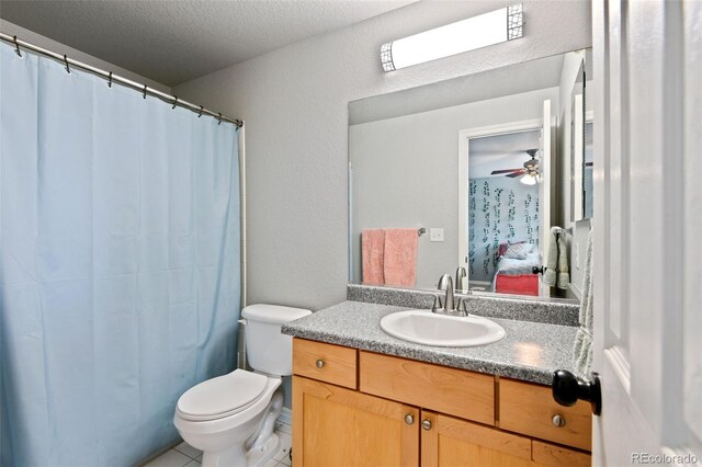 879 Quintana Ln, Erie, CO 80516 - bathroom with vanity, toilet, connected bathroom, tile patterned floors, and a textured ceiling