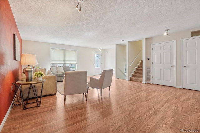 2173 S Ouray St, Aurora, CO 80013 - dining room featuring a textured ceiling, stairs, and wood finished floors