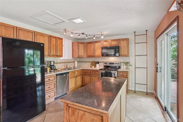 2173 S Ouray St, Aurora, CO 80013 - kitchen featuring black appliances, light tile patterned floors, backsplash, brown cabinets, and a textured ceiling