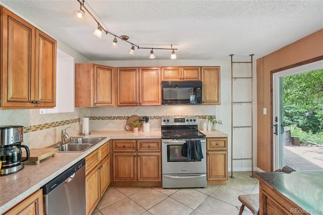 2173 S Ouray St, Aurora, CO 80013 - kitchen with appliances with stainless steel finishes, brown cabinetry, a textured ceiling, and tasteful backsplash