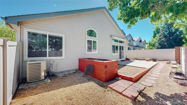 back of property with central AC, a patio, and a fenced backyard