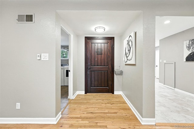 4465 Zephyr St, Wheat Ridge, CO 80033 - foyer featuring light wood finished floors and washing machine and dryer