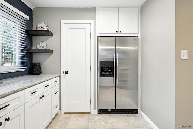 4465 Zephyr St, Wheat Ridge, CO 80033 - kitchen with stainless steel refrigerator with ice dispenser, white cabinetry, open shelves, and light stone counters