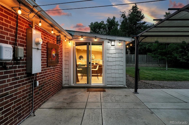 4465 Zephyr St, Wheat Ridge, CO 80033 - exterior entry at dusk with a patio and brick siding