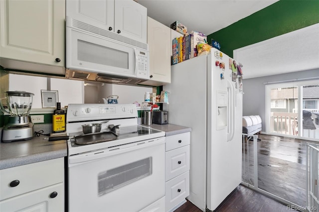 kitchen with white cabinets, dark wood-type flooring, and white appliances