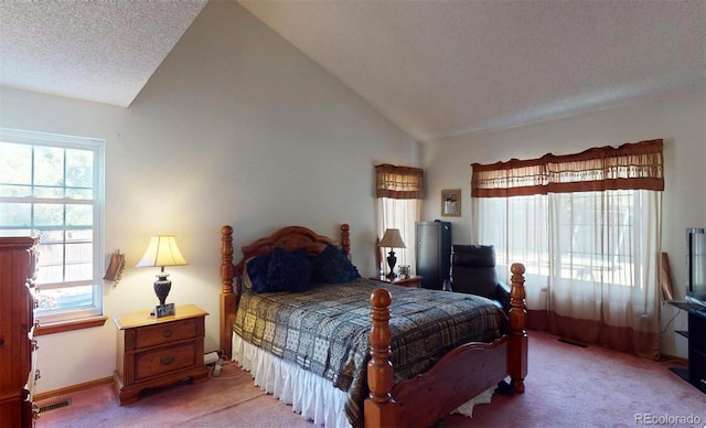 carpeted bedroom with a textured ceiling and vaulted ceiling