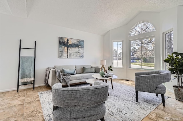 living area featuring baseboards, plenty of natural light, a textured ceiling, and lofted ceiling
