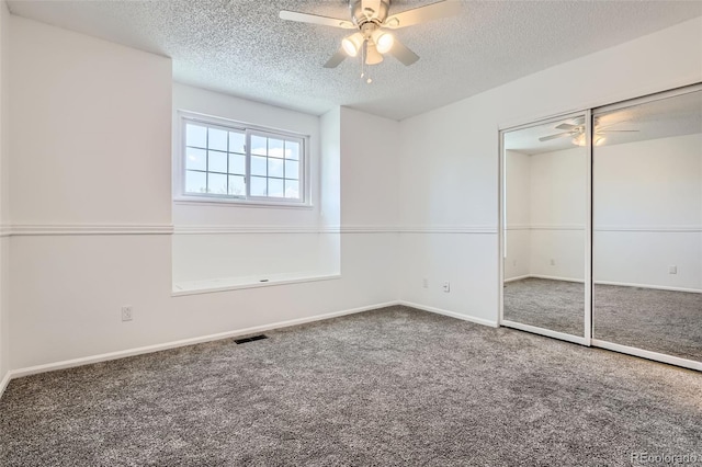 unfurnished bedroom featuring a textured ceiling, visible vents, baseboards, a closet, and carpet flooring
