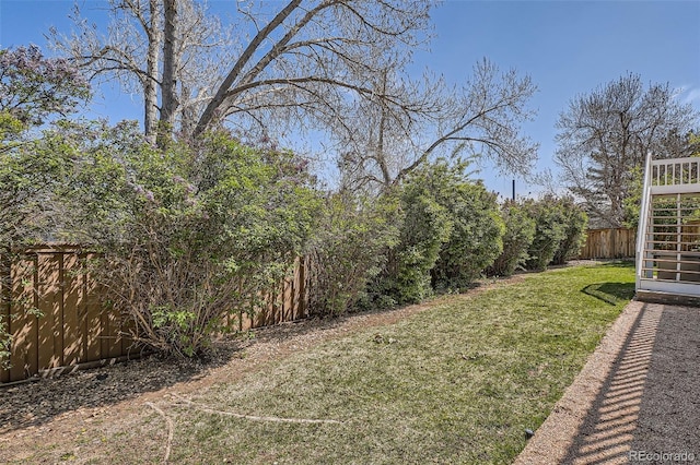 view of yard featuring stairway and a fenced backyard
