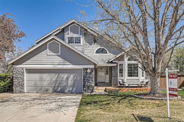 view of front of house featuring an attached garage, driveway, and stone siding