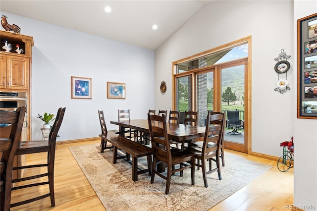 dining room with light hardwood / wood-style floors and lofted ceiling