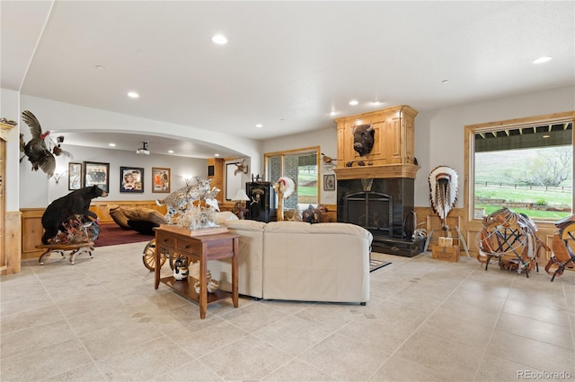 living room with a fireplace and wooden walls