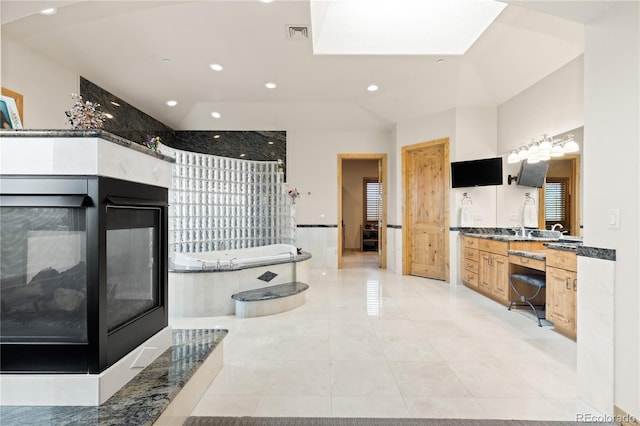 interior space with tile patterned flooring, vanity, and a washtub