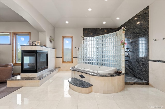 bathroom featuring a multi sided fireplace, separate shower and tub, and plenty of natural light