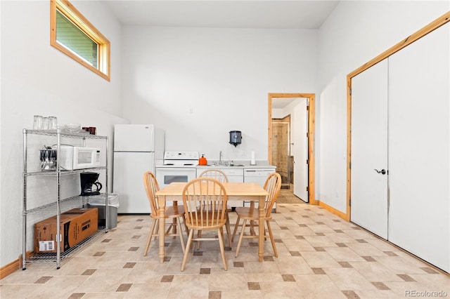 dining room featuring a towering ceiling and sink