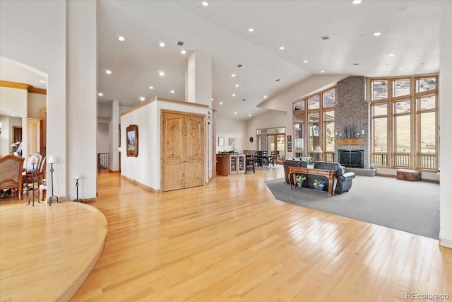 5881 Deer Meadow Trl, Golden, CO 80403 - living area with high vaulted ceiling, a brick fireplace, light wood-style floors, recessed lighting, and arched walkways