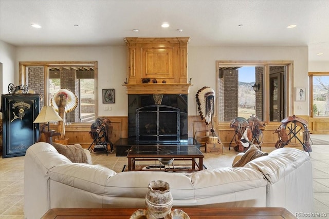 5881 Deer Meadow Trl, Golden, CO 80403 - living room featuring wainscoting, recessed lighting, a fireplace, light tile patterned floors, and wooden walls