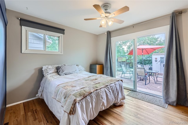 bedroom featuring hardwood / wood-style flooring, ceiling fan, access to exterior, and multiple windows