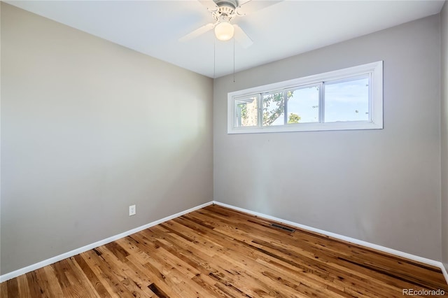 empty room with hardwood / wood-style floors and ceiling fan