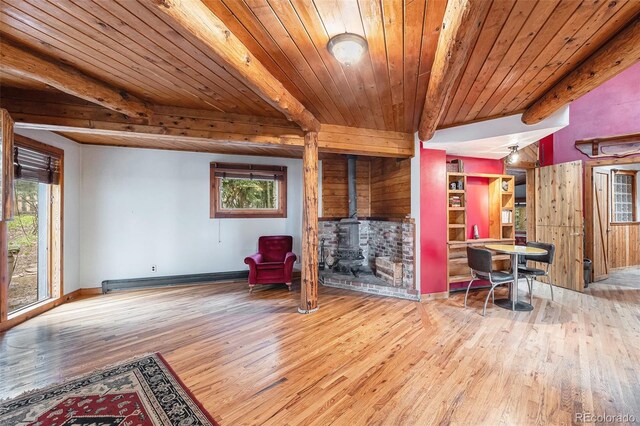 10419 Christopher Dr, Conifer, CO 80433 - living area featuring hardwood / wood-style flooring, a wood stove, wooden ceiling with exposed beams, a baseboard heating unit, and baseboards